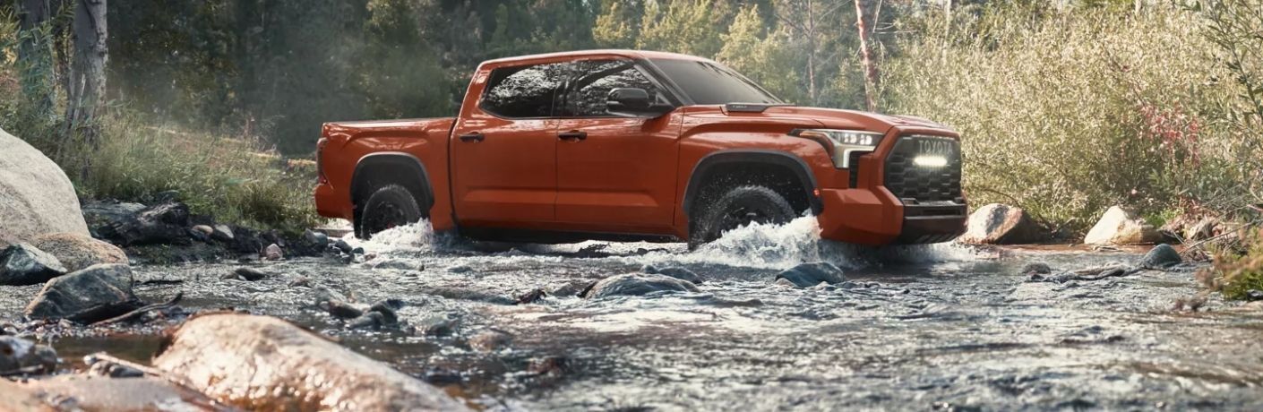 A 2024 Toyota Tundra trudging through a rocky ford