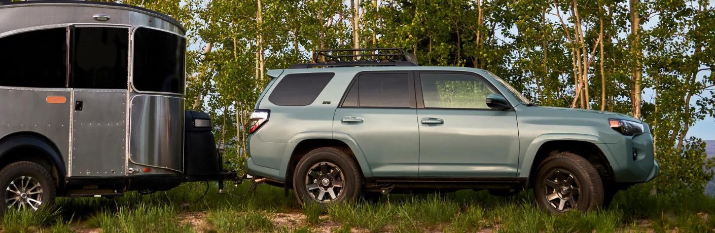 One green color 2022 Toyota 4Runner is parked in the middle of a forest.
