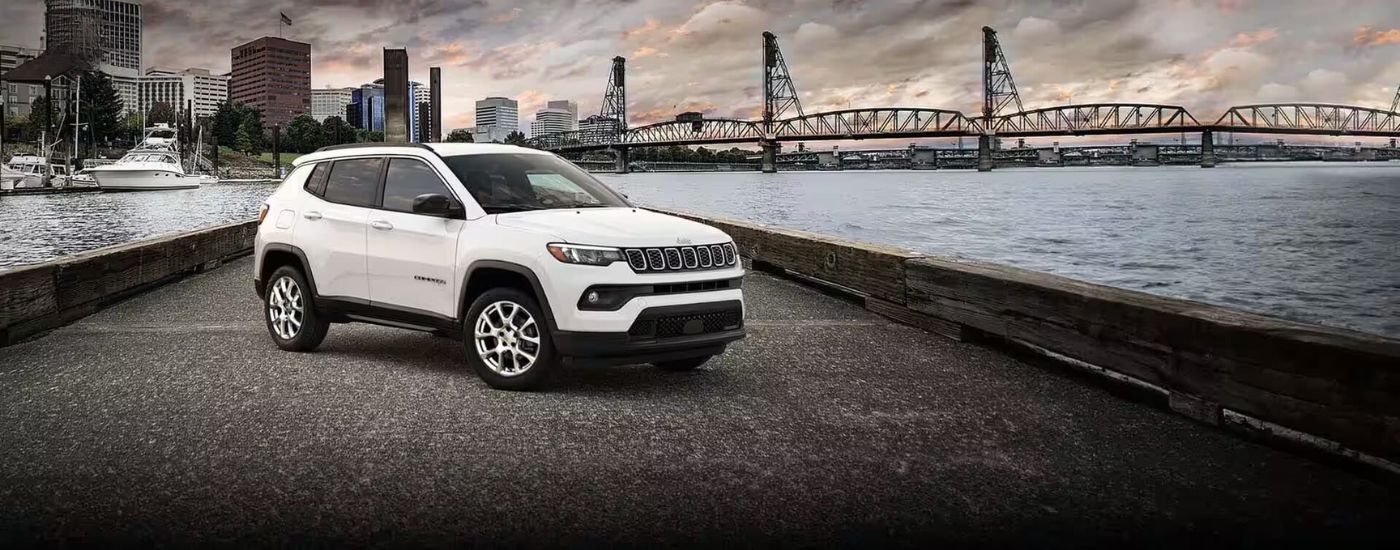 White used 2024 Jeep Compass for sale parked near a bridge