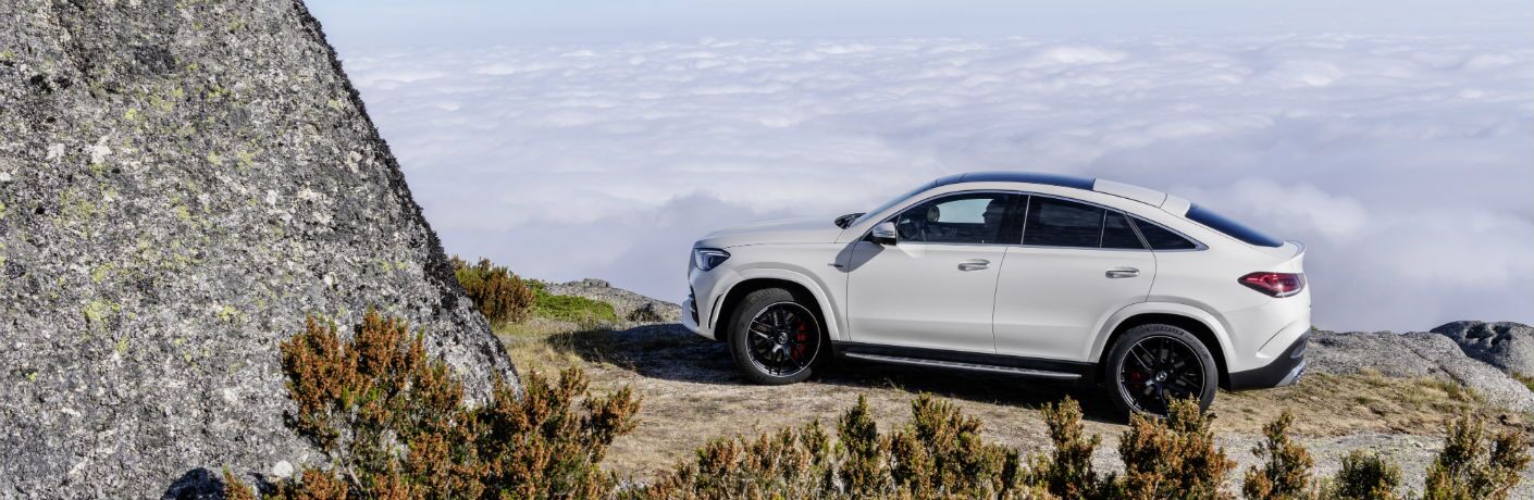 2021 MB AMG GLE Coupe exterior driver side on cliff with rocks and clouds