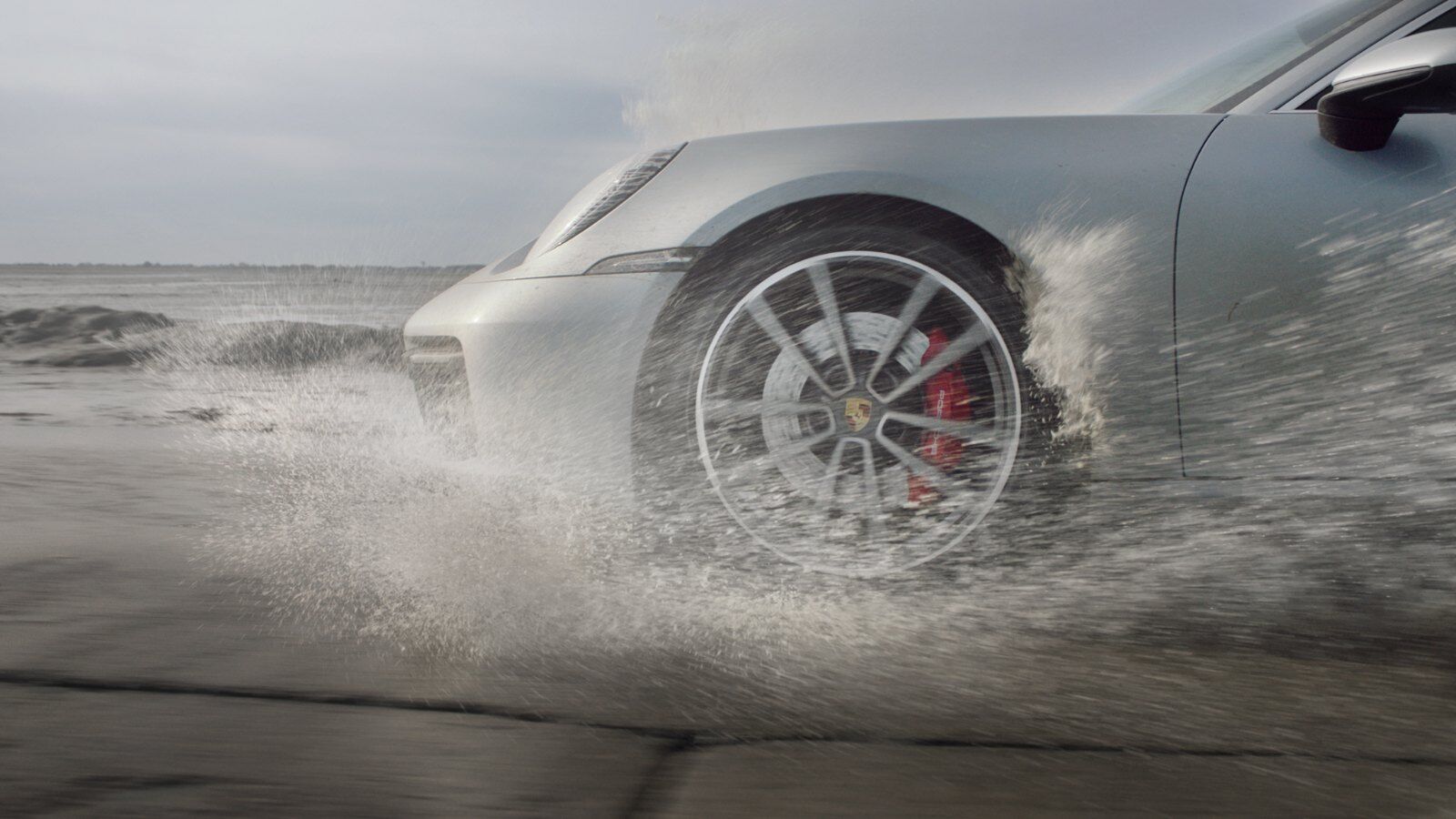 Porsche 911 driving a wet causeway in heavy rain – Champion Porsche Pompano Beach, FL