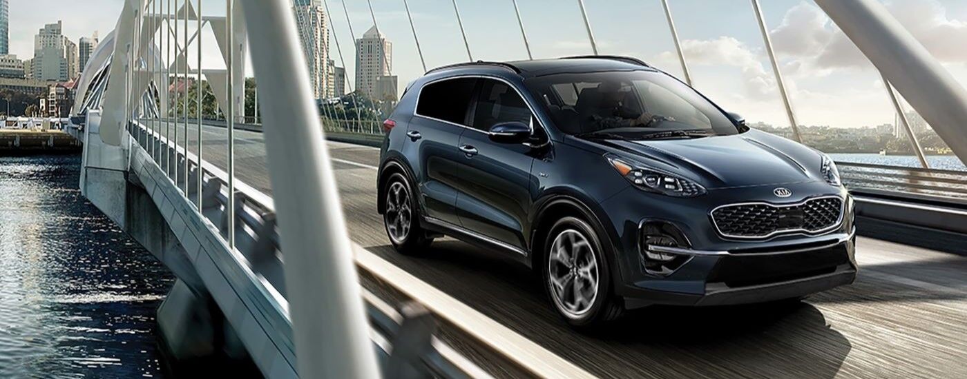Blue 2020 Kia Sportage driving over a bridge