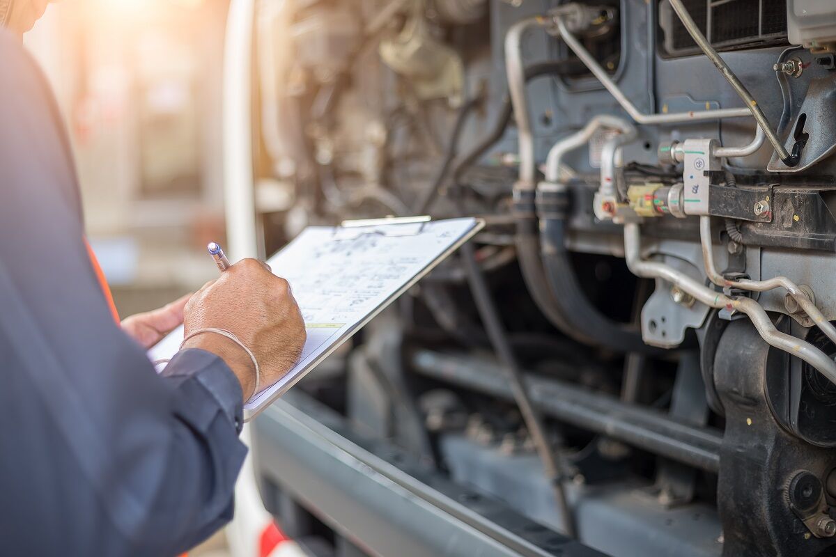 A man checking a commercial truck repair checklist