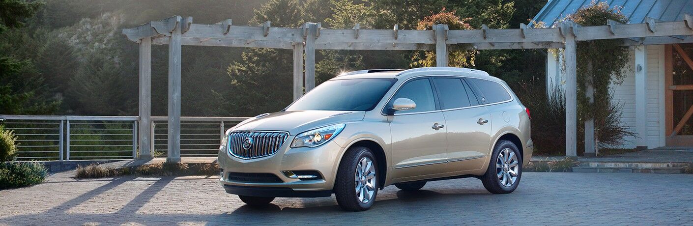 2017 Buick Enclave beige exterior driver side front parked near wooden terrace