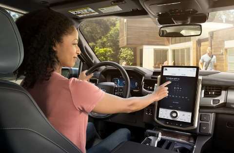 2022 Ford F-150 Lightning Driver interacting with Touch Screen