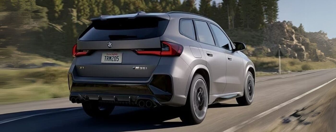 Grey 2025 BMW X1 M35i driving down an open road.