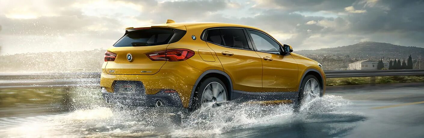 2022 Yellow BMW X2 driving through stream