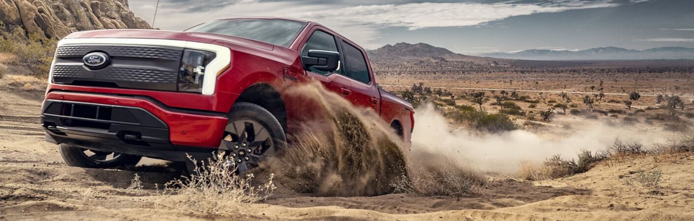 The Ford F-150 Lightning EV driving aggressively off-road.
