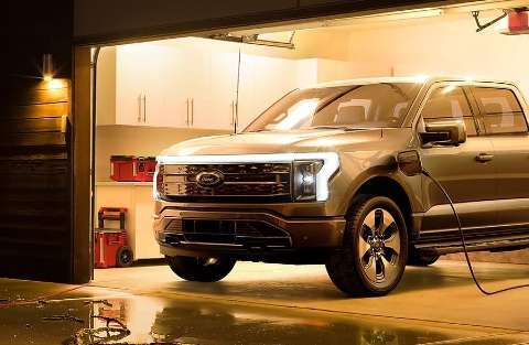 2022 Ford F-150 Lightning inside a home garage plugged in for charging