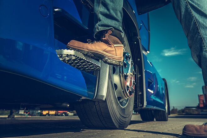 Man standing on semi truck step