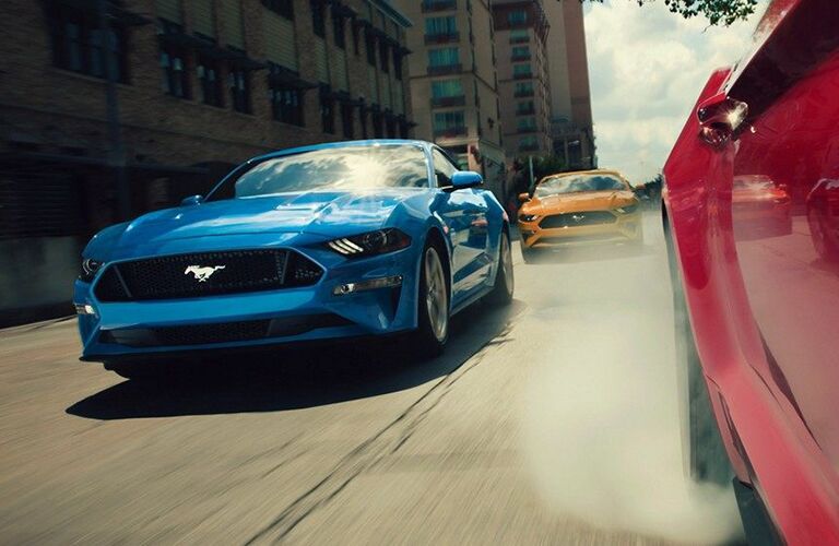 Three 2019 Ford Mustang models racing down road