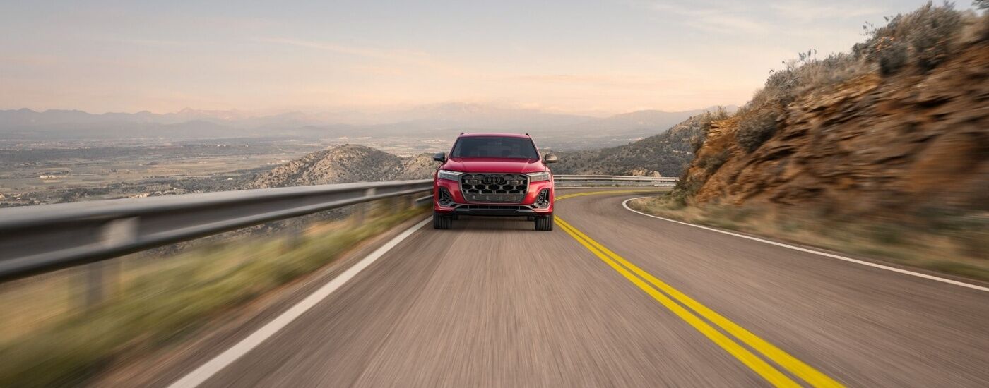Red 2025 Audi Q7 driving on a winding road