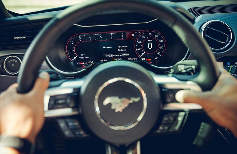 Hands gripping 2019 Ford Mustang GT steering wheel