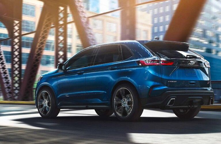 Blue 2019 Ford Edge SEL driving over city bridge