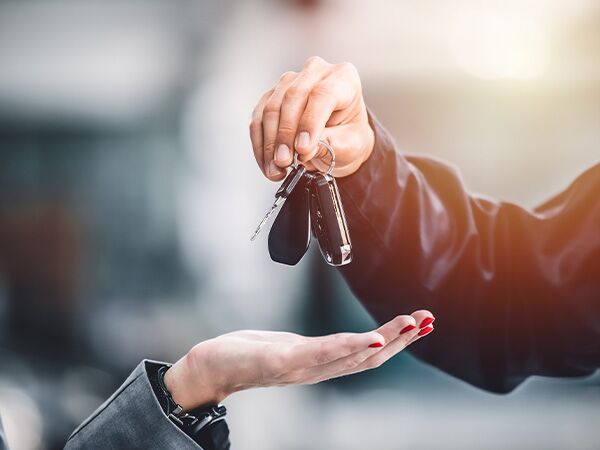 Close up of a person holding keys over a customers hand