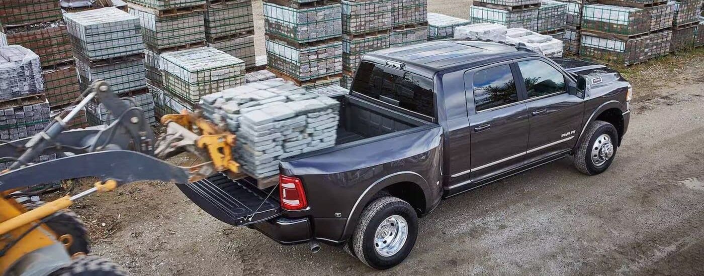 Stones being loaded into the bed of a grey 2024 Ram 3500