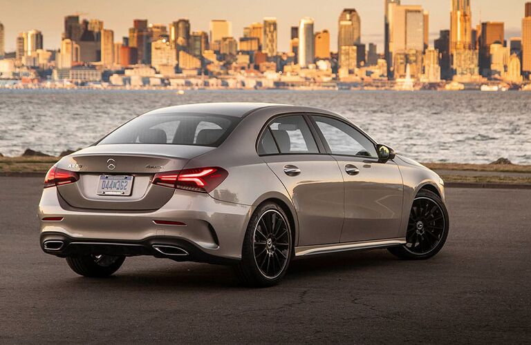 2021 MB A-Class exterior rear fascia passenger side in front of water with city in distance