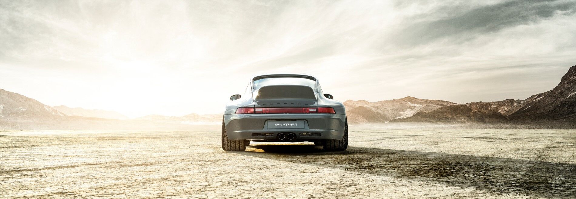 Porsche Coupe rear view parked in a barren landscape
