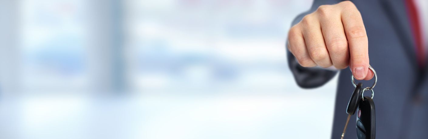 Car sales officer holding a car key in his hands