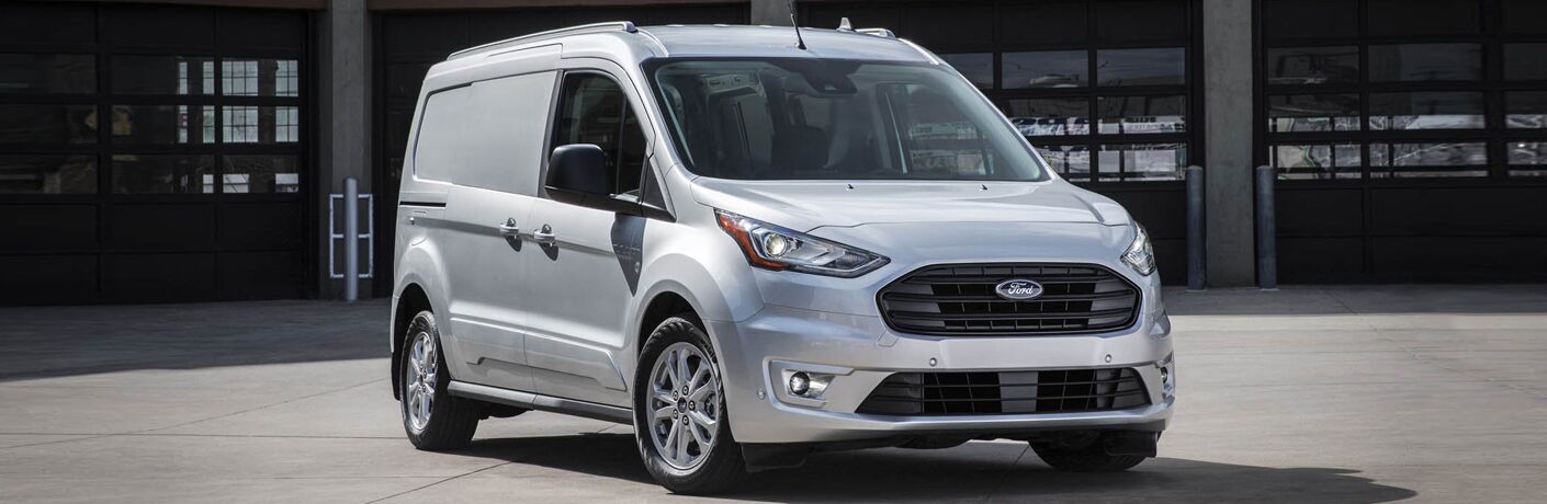 Front view of white 2020 Ford Transit Connect parked in front of building