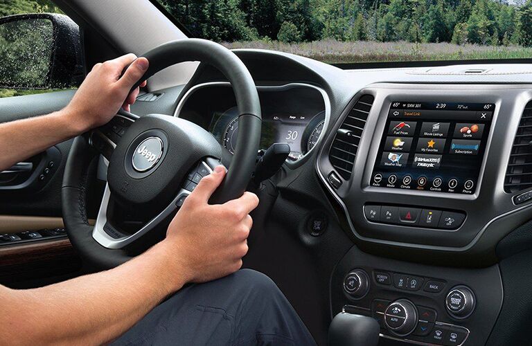 A person holding the steering wheel of the 2019 Jeep Cherokee.