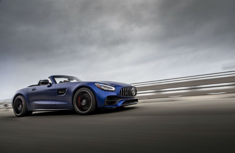 2019 MB GT Roadster exterior front fascia and passenger side on blurred road with storm clouds above