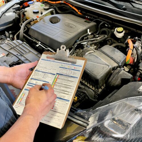 Ford mechanic inspecting and diagnosing Ford vehicle engine bay Sherwood Ford service center near Edmonton
