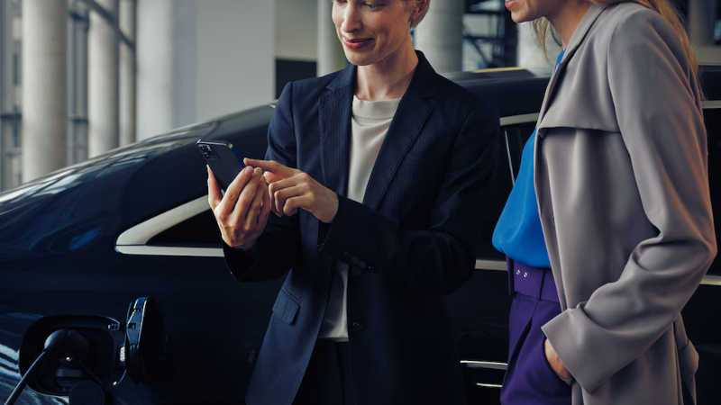 A woman monitoring charging on her Mercedes EV with the Mercedes App