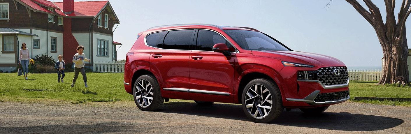 A family running toward a parked 2021 Hyundai Santa Fe