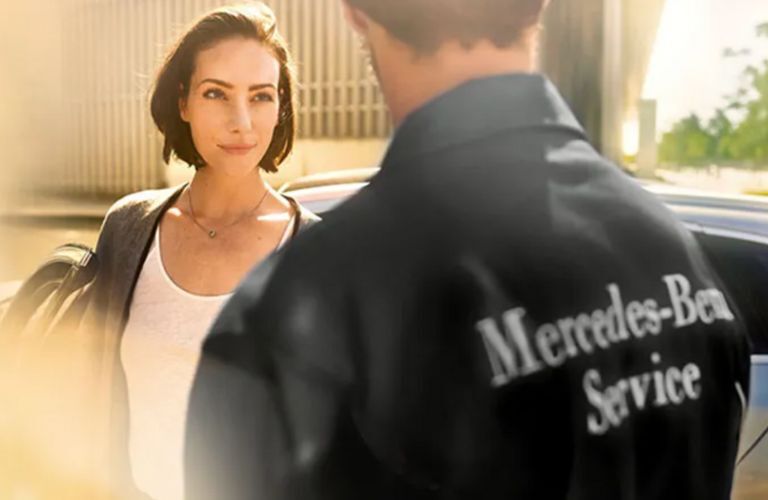 a woman talking to a Mercedes-Benz service technician