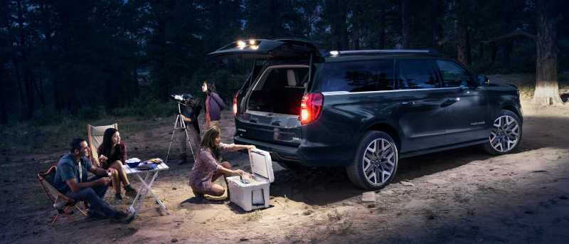 The 2027 Ford Expedition with multi-fold tailgate in use at a campsite.