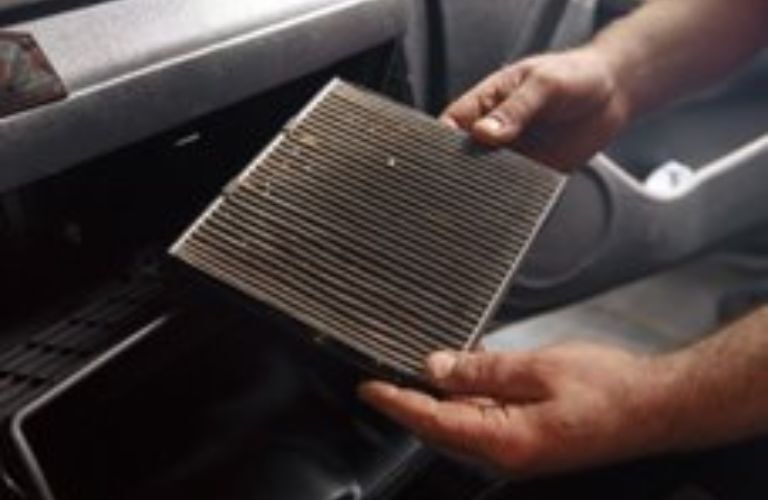 image of a technician holding a cabin air filter