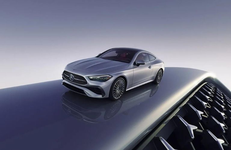 a visualization image of a 2024 Mercedes-Benz CLE Coupe on a glossy road with Mercedes-Benz logos