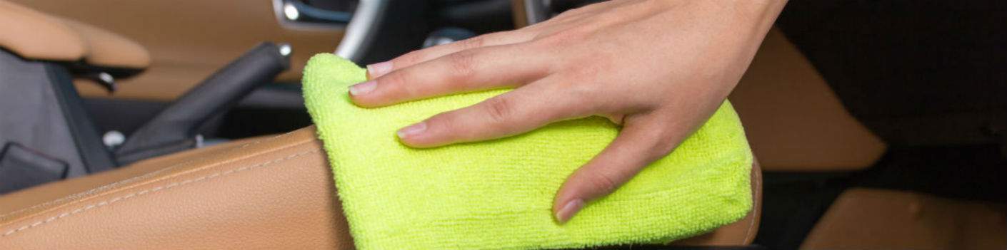 closeup of a hand wiping down leather seats in a car