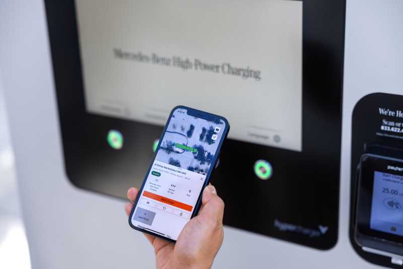 A person using the Mercedes-Benz app to begin charging their vehicle at an 800V high-power charging station