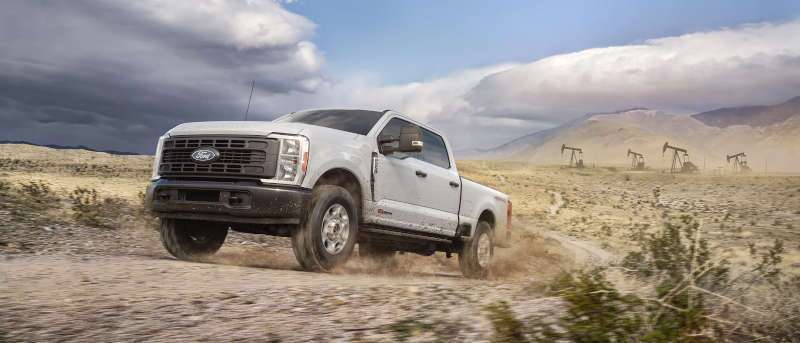 The 2027 Ford F-250 Super Duty tackling rough terrain near an oil field job site