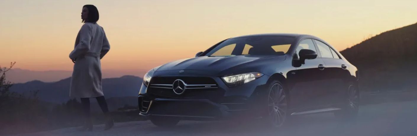 a woman standing in front of a Mercedes-Benz