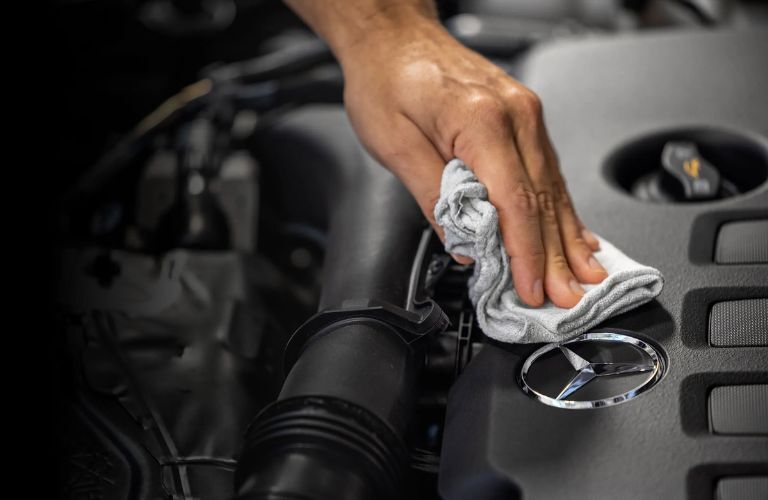 technician wiping the Mercedes-Benz badging in a car