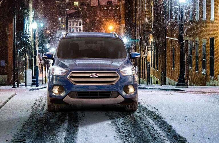 Front view of blue 2019 Ford Escape driving through snow