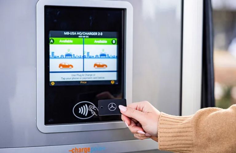 a woman's hand activating Mercedes-Benz card for payment