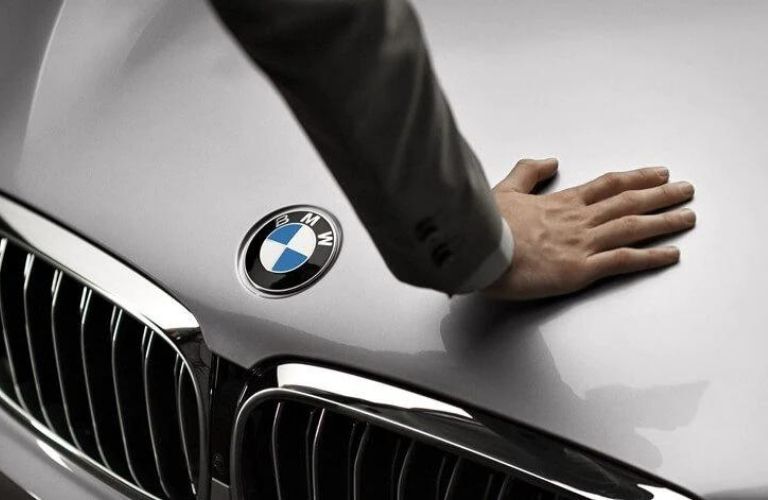 Hand placed on the hood of a BMW