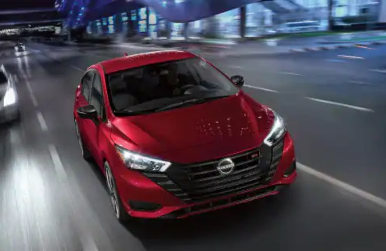 Red Nissan Versa on the road