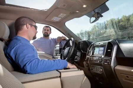 Two men sitting and talking inside 2019 Ford F-150 Platinum