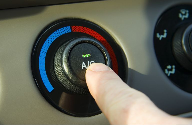 finger starting the AC in a car