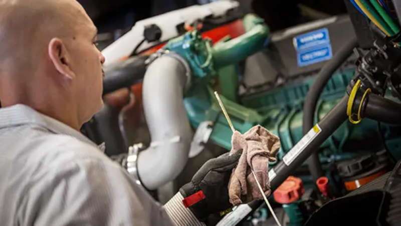 A TruckMax commercial truck technician installing Volvo OEM parts on a Volvo commercial truck