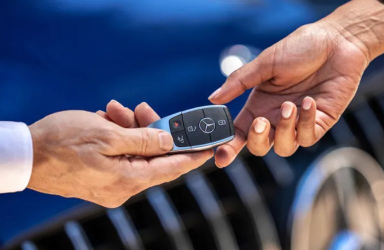 Tow hands holding Mercedes-Benz key