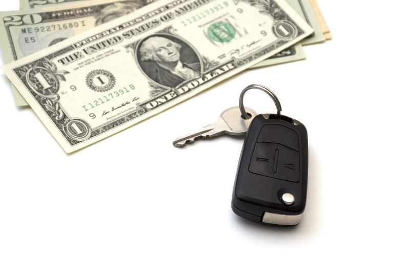 a car key and cash on a white background