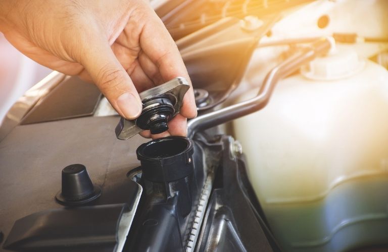 technician checking the coolant in a car