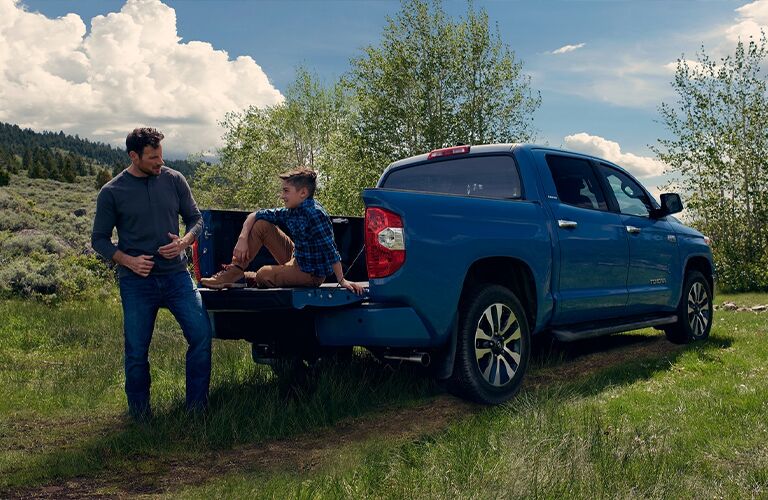 A father and son leaning against a 2021 Toyota Tundra
