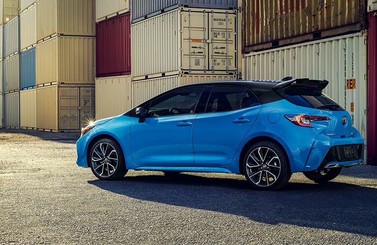 Blue 2021 Toyota Corolla Hatchback driving by shipping containers